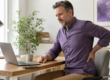 Professional experiencing lower back discomfort during a screen-heavy workday